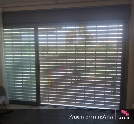 תריסי אלומיניום על חלון זכוכית גדול